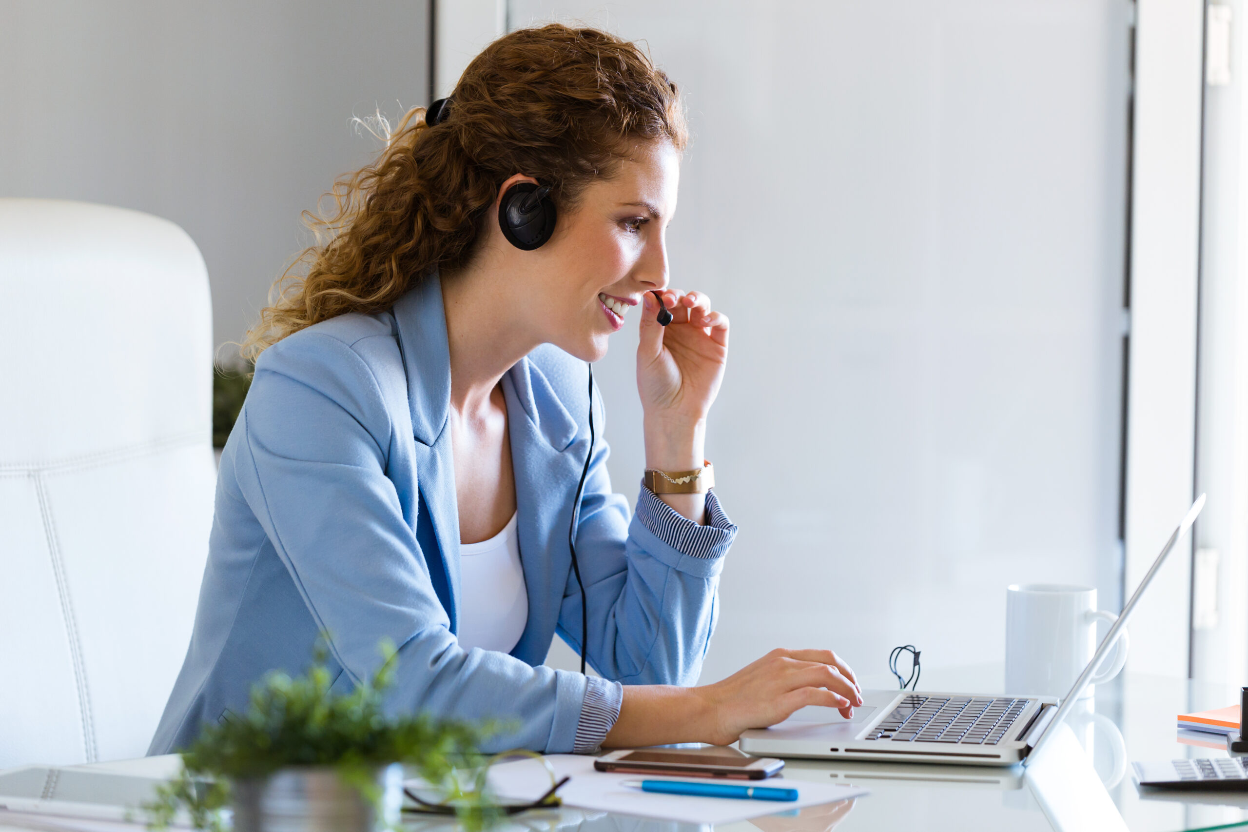 Portrait of customer service operator talking on phone in the office.